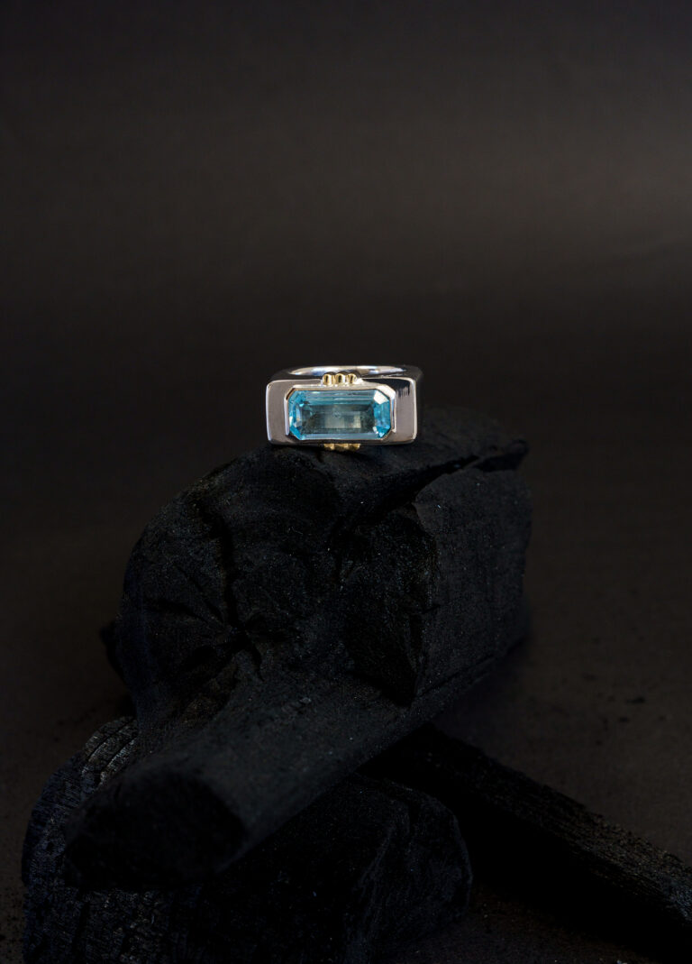 Anel Conexão em prata 950 com banho em ouro branco 18k, garras em ouro amarelo 18k, topázio azul e estrelas de diamantes brancos